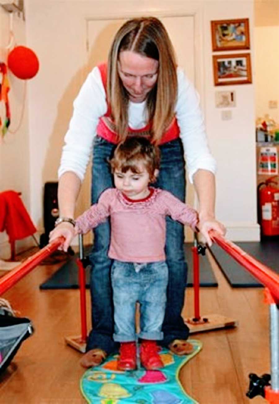 A little girl learns to walk at therapy