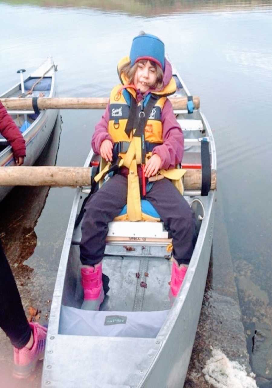 A girl with CdLS sits in a canoe