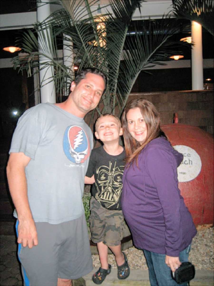 A woman stands with her husband and son