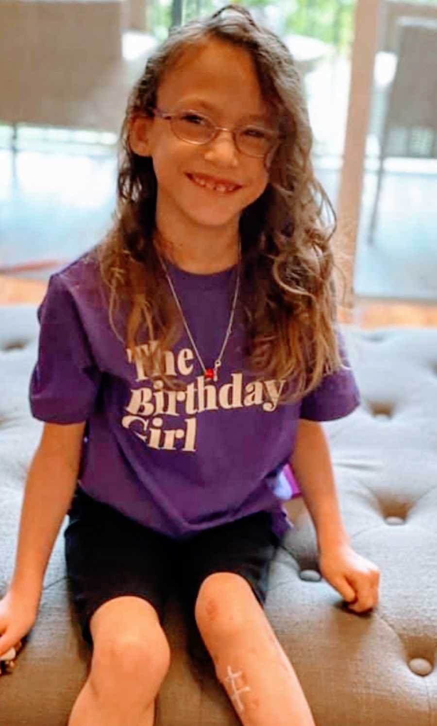 A young girl wearing a purple shirt