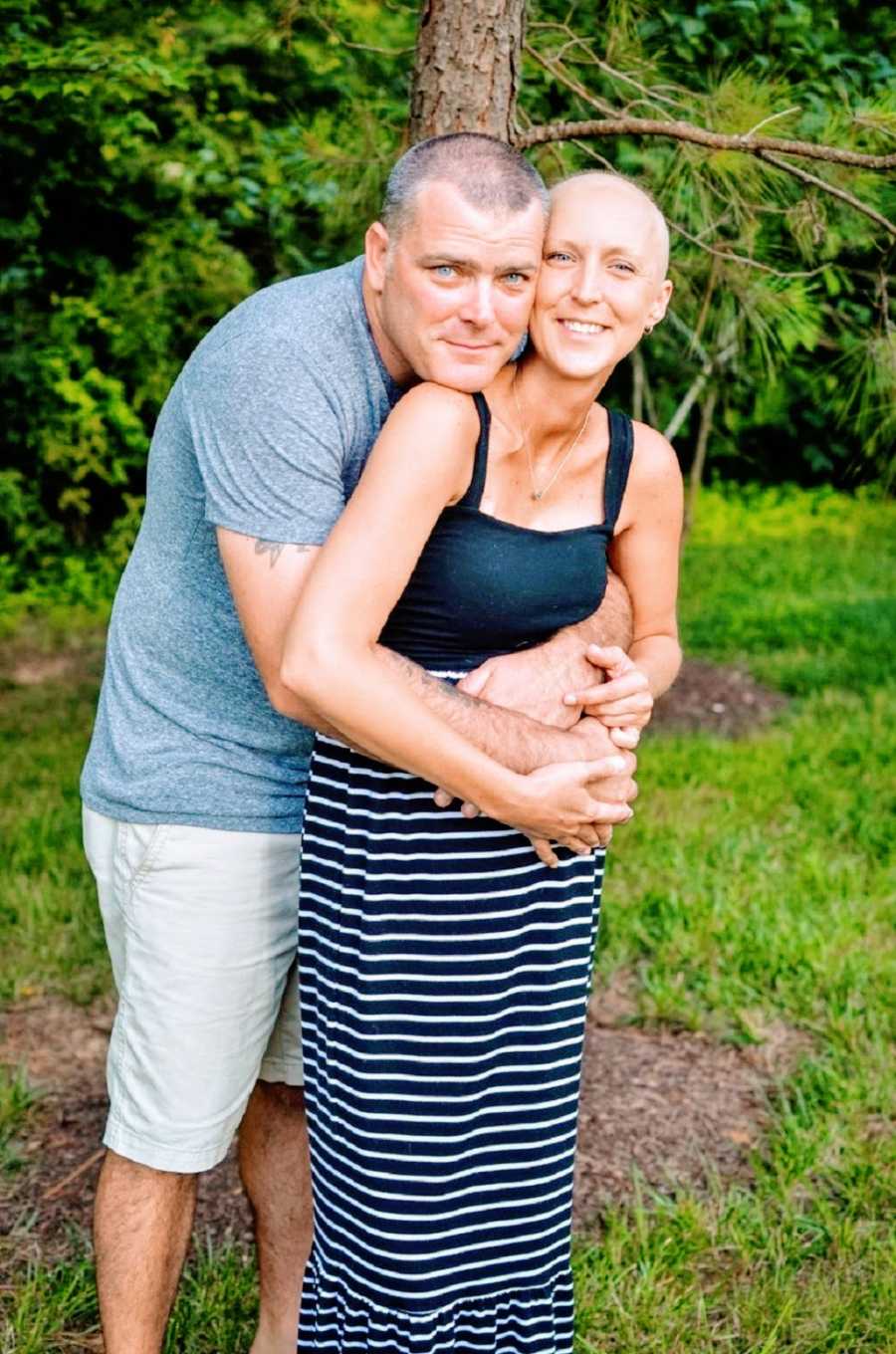 A husband hugs his wife who has cancer