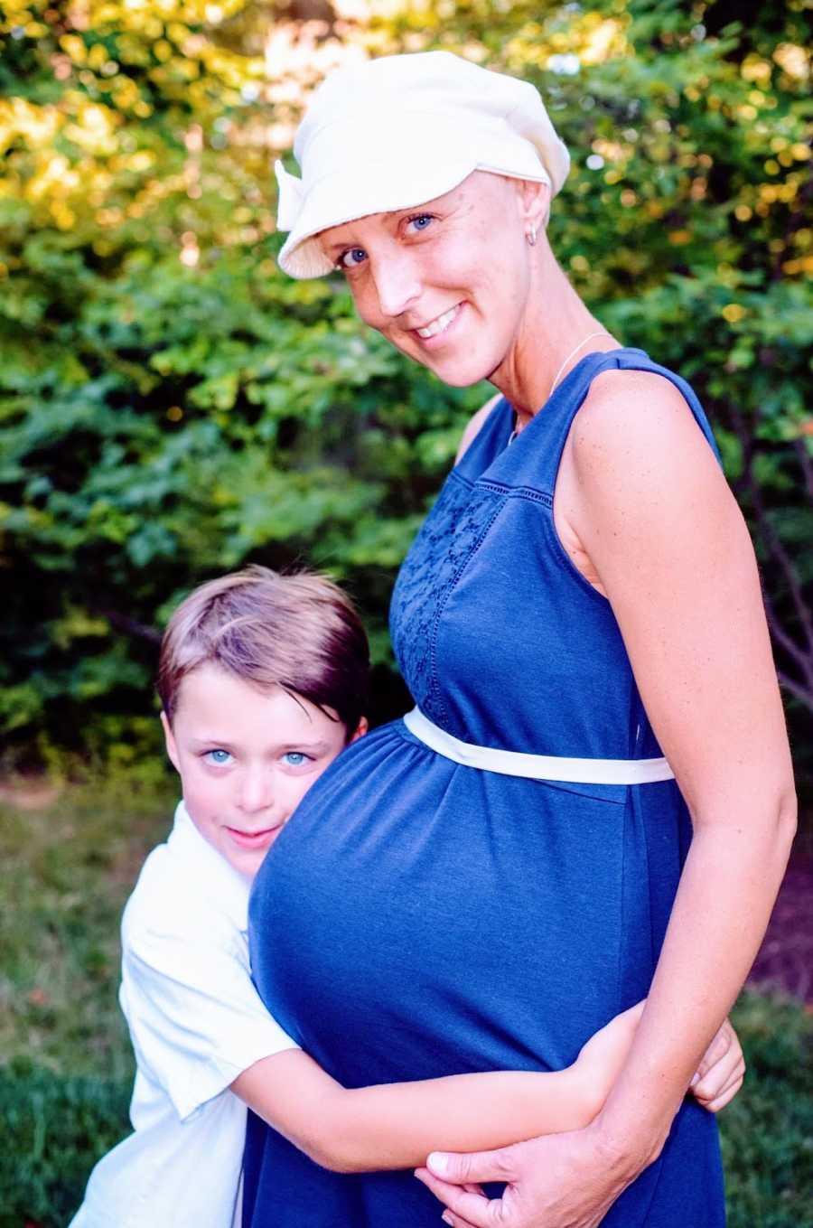 A little boy hugs his pregnant mother's stomach