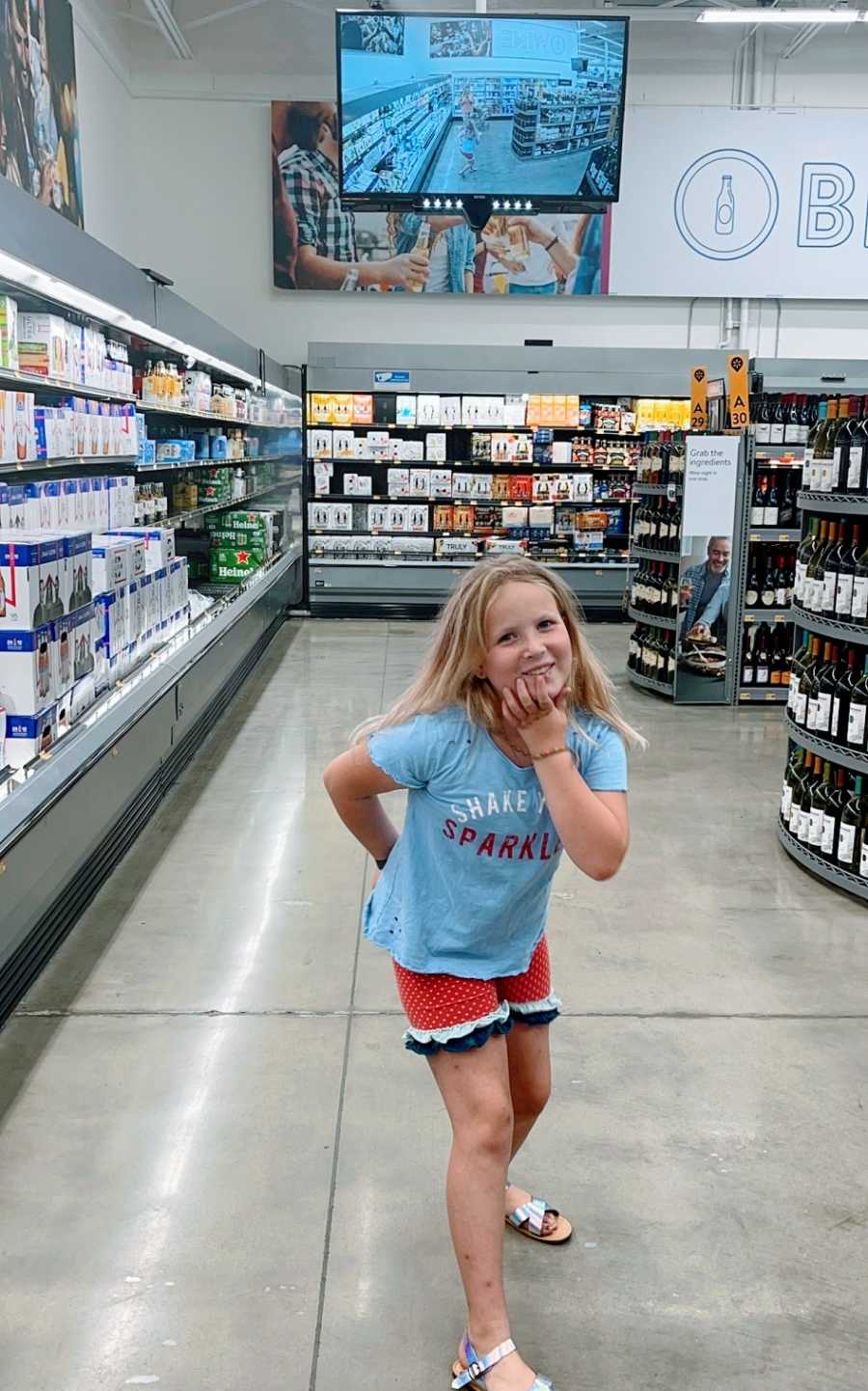 A little girl poses in the grocery store