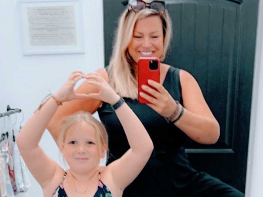 一个女人在镜子前给自己和女儿拍了张照片