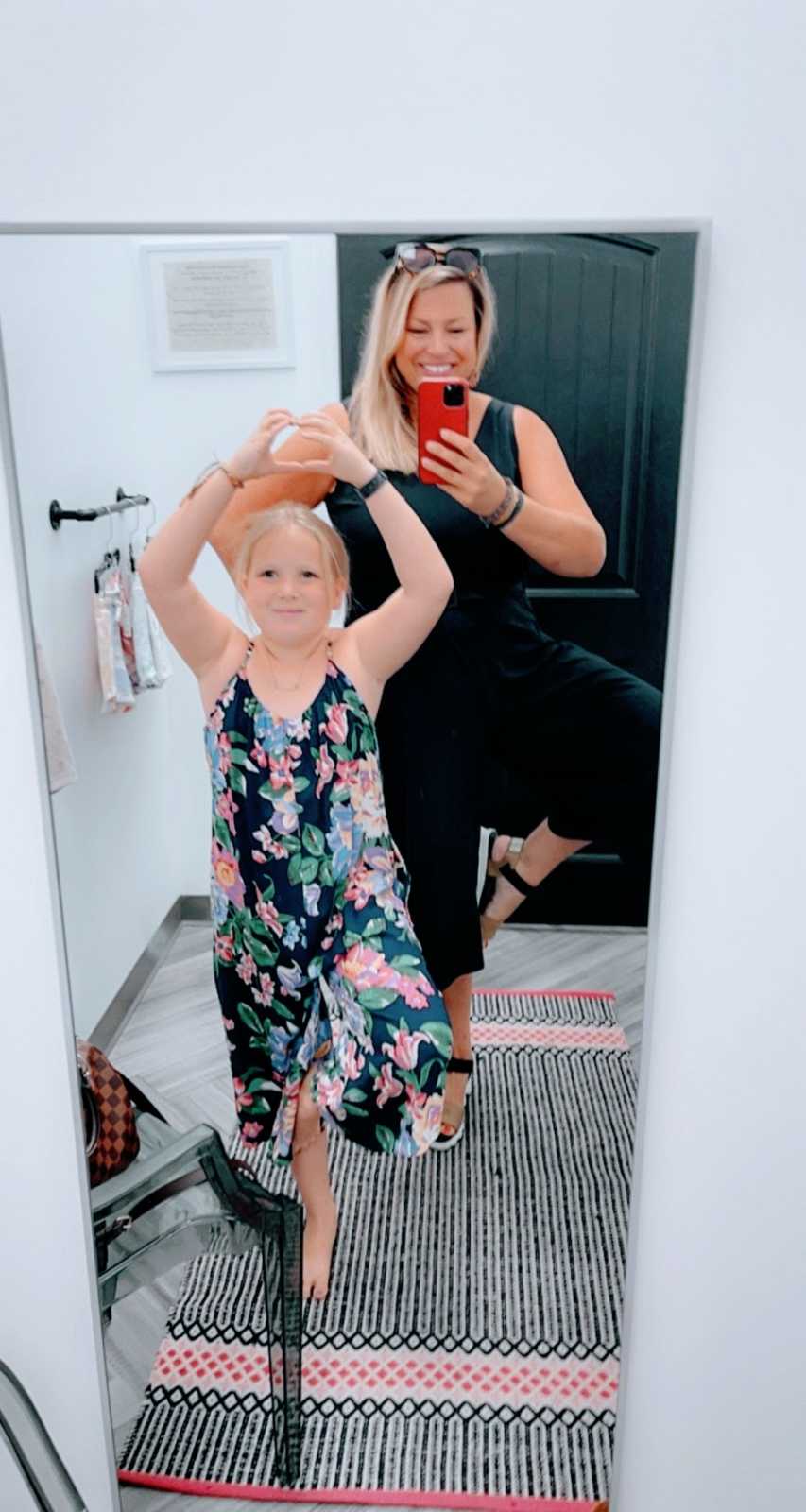 A woman takes a photo of herself and her daughter in a mirror