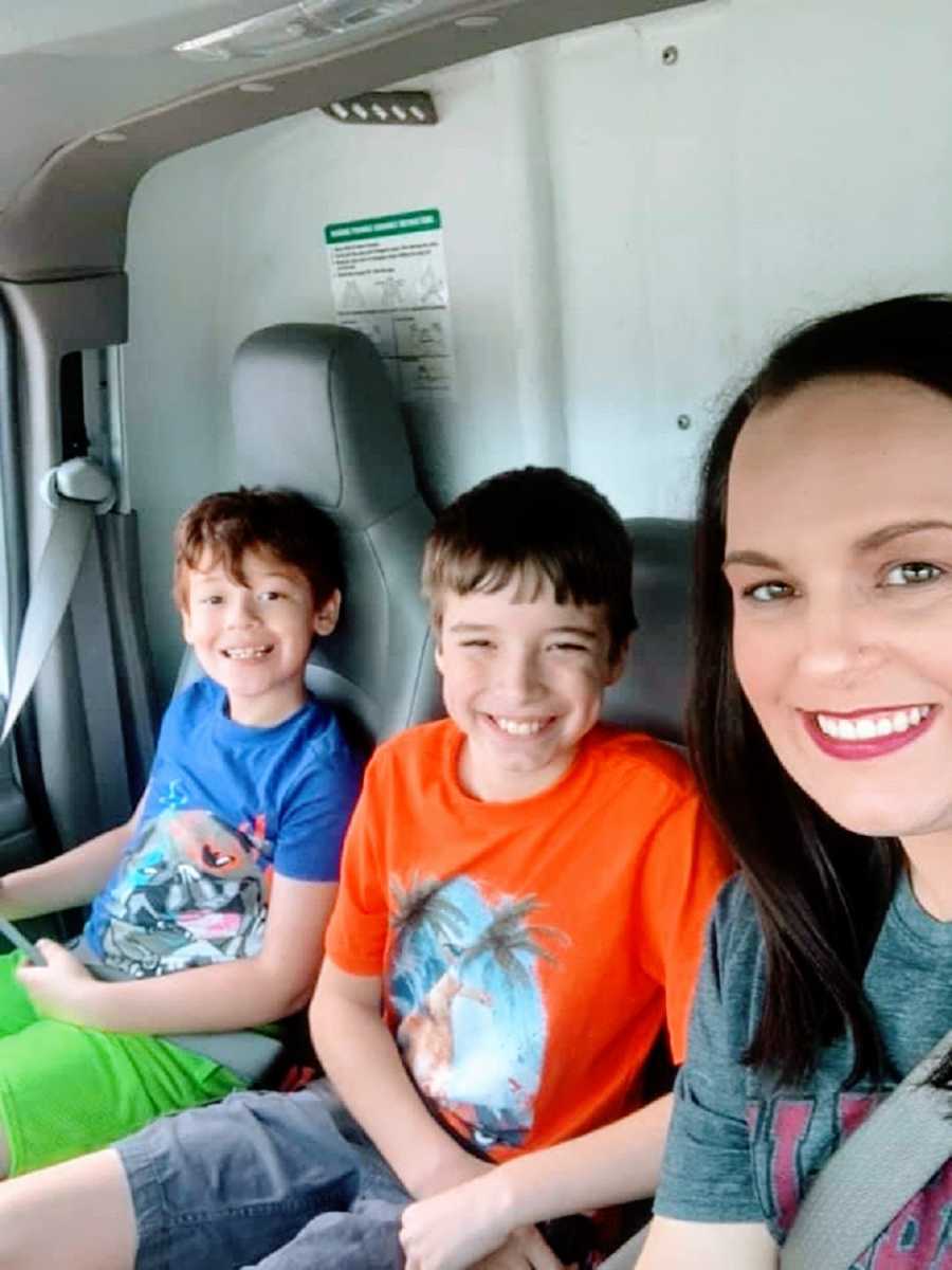 A mom sits in a truck with her two sons