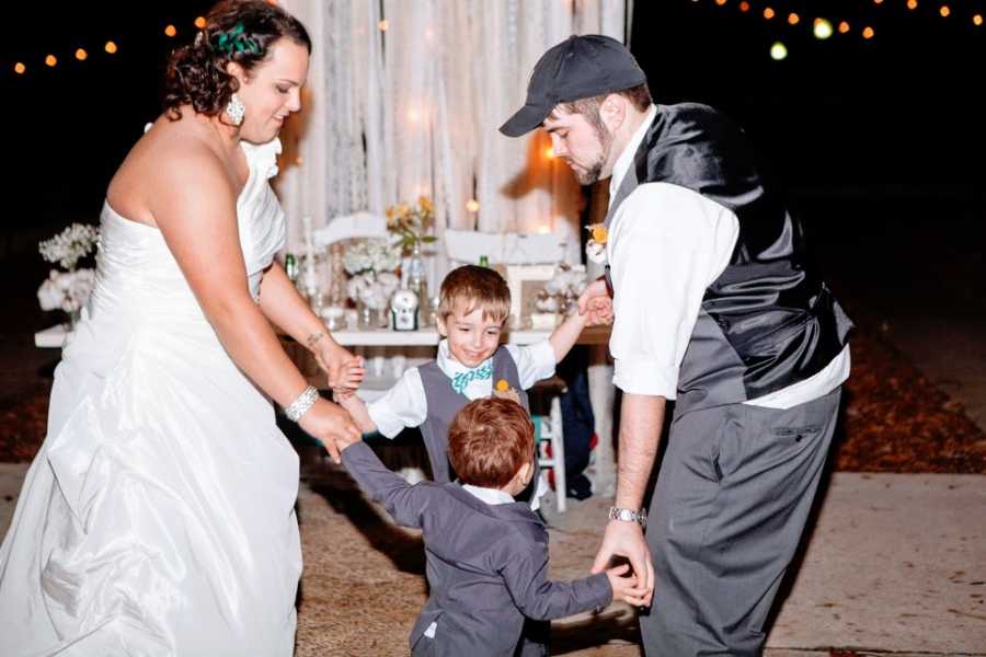 A woman and her husband stands with their two children