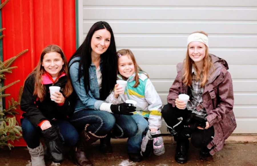 A mother sits with her three young daughters