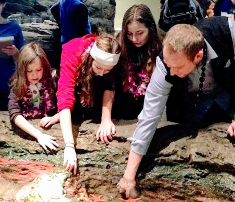 Parents and their three daughters at an aquarium