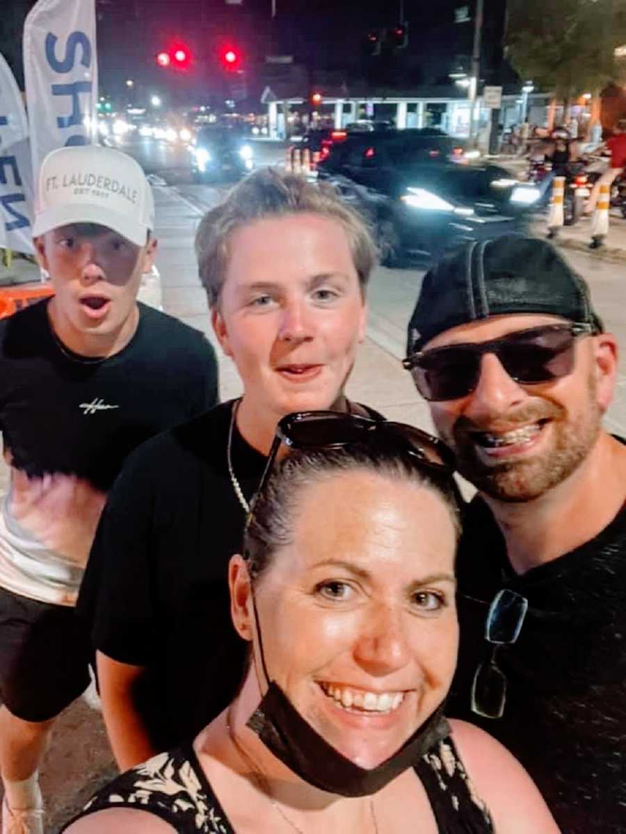 A family with two sons stand out on a street together