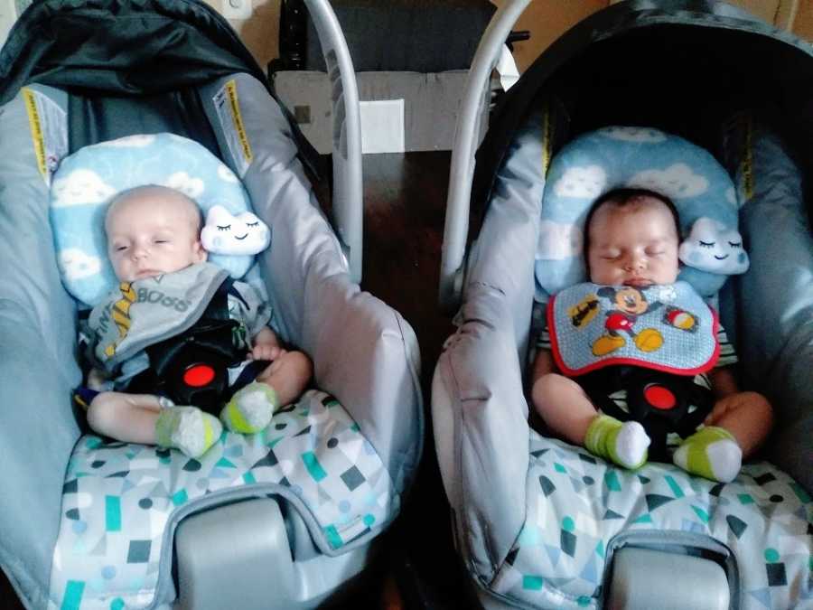 Twin boys sit in matching carseats