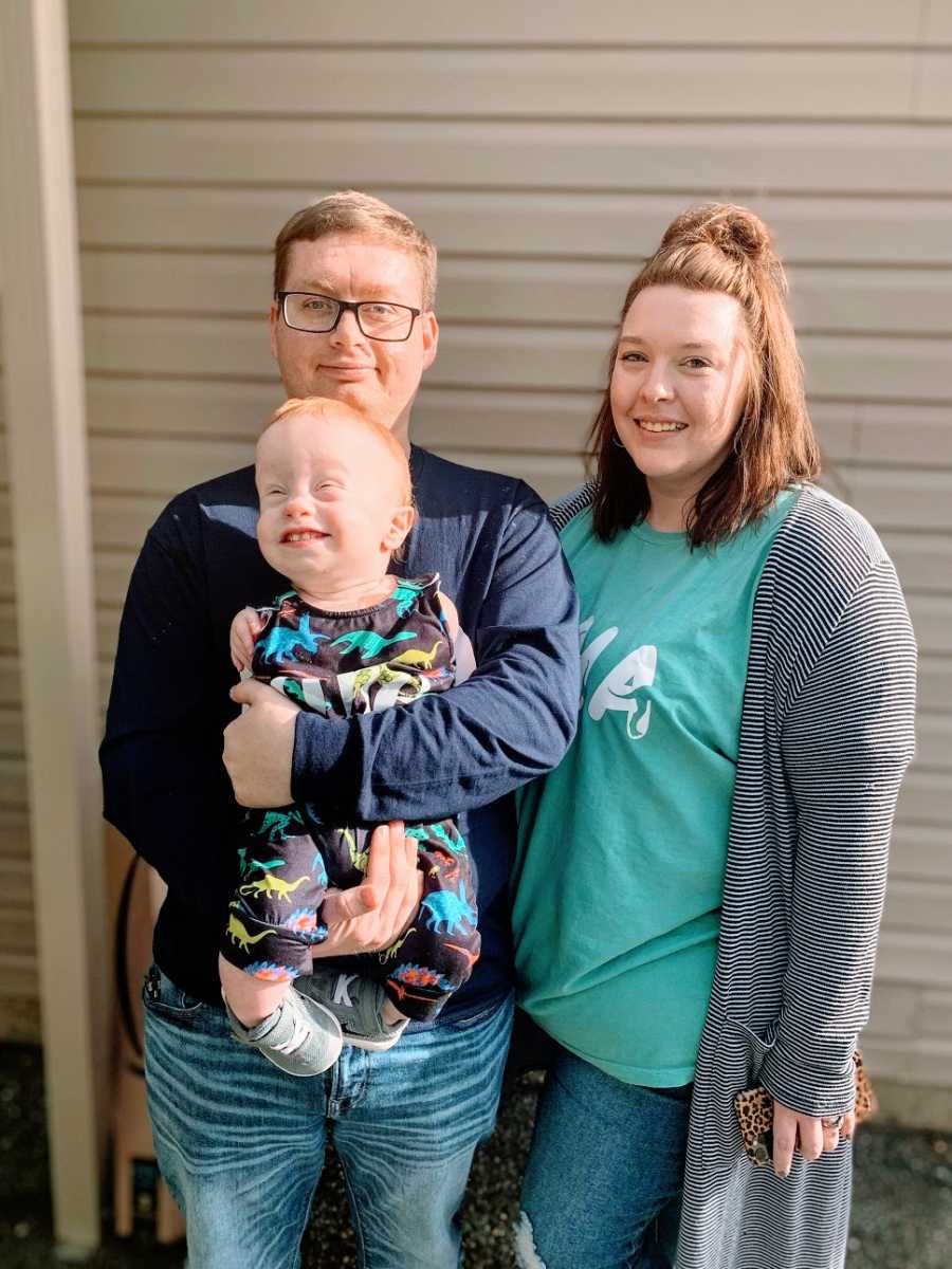 Parents hold their toddler with no arms 