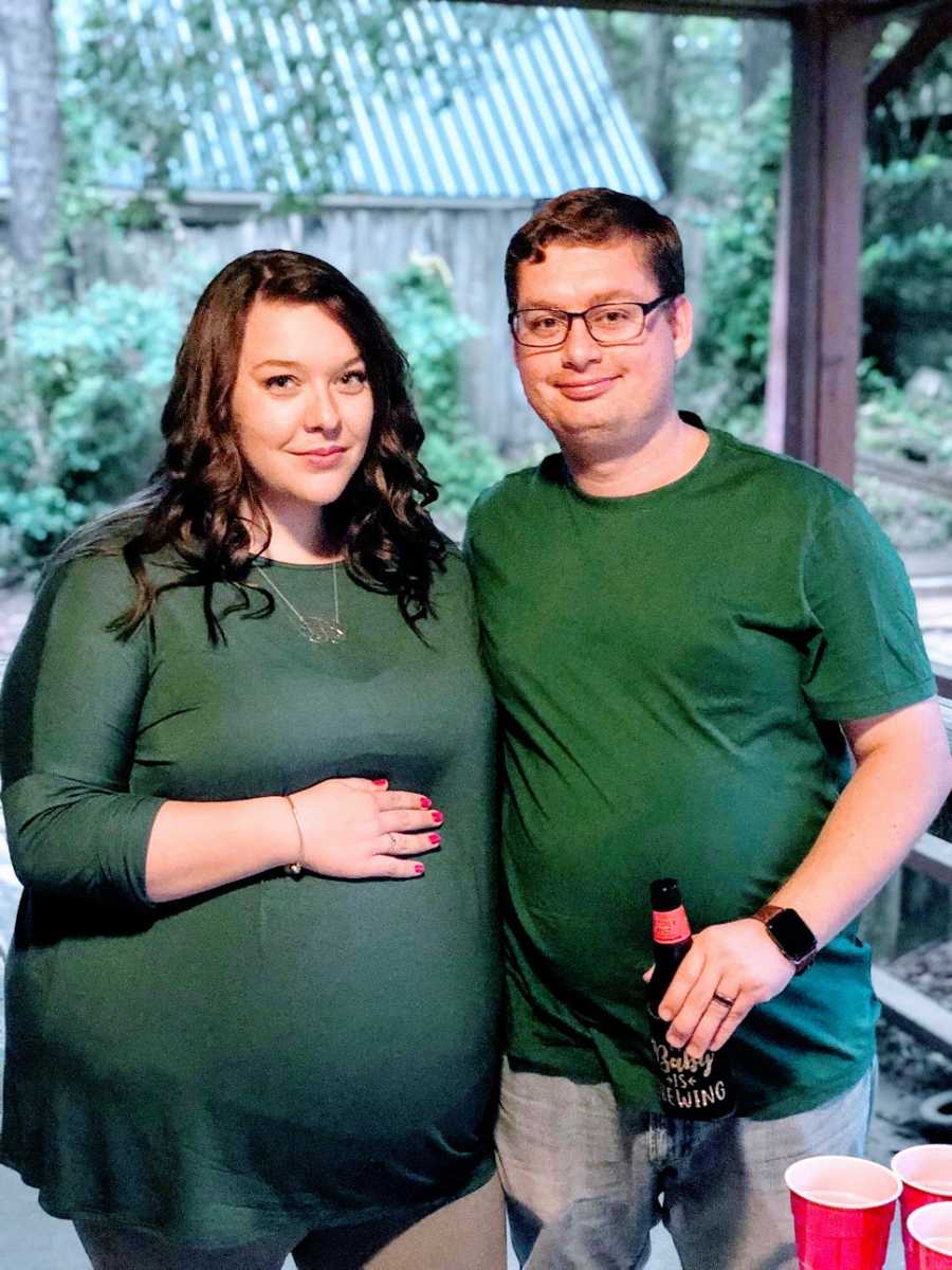 A pregnant woman and her husband wearing green shirts