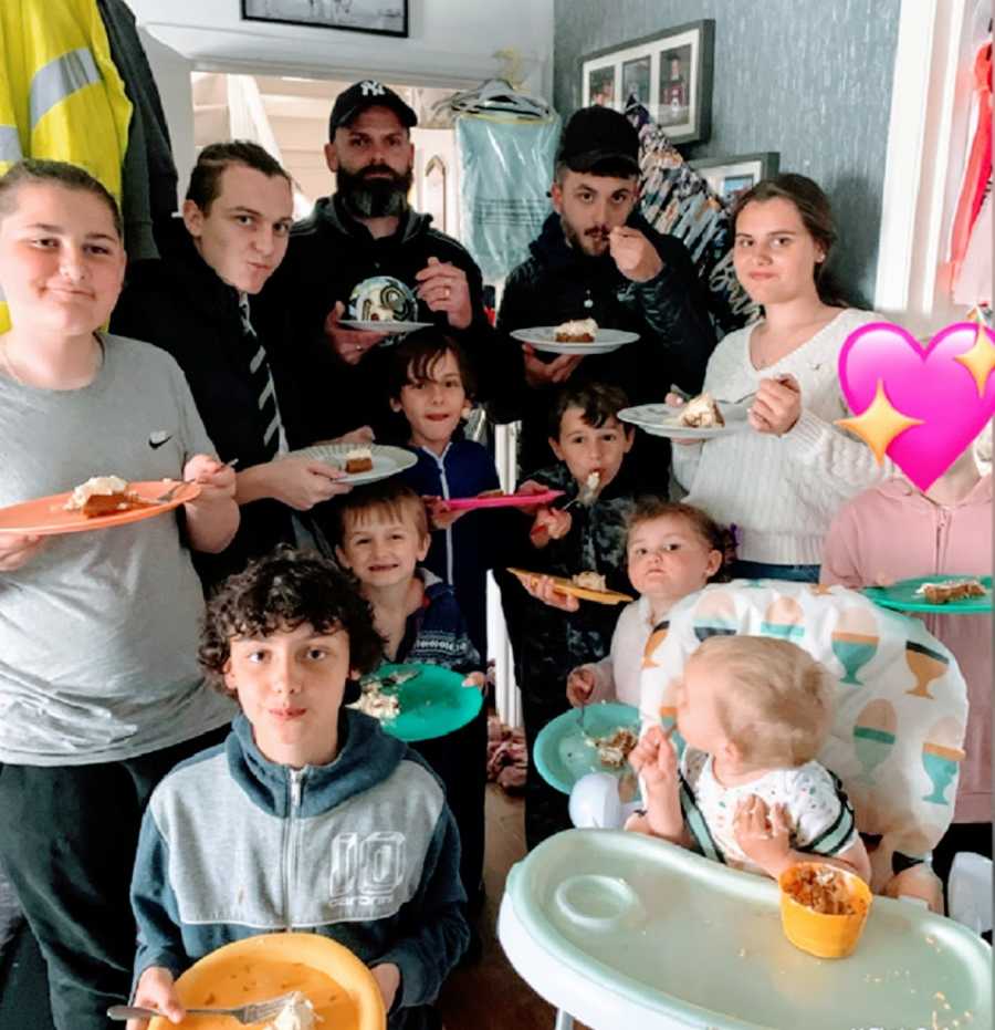 A family with eleven kids stands in the kitchen