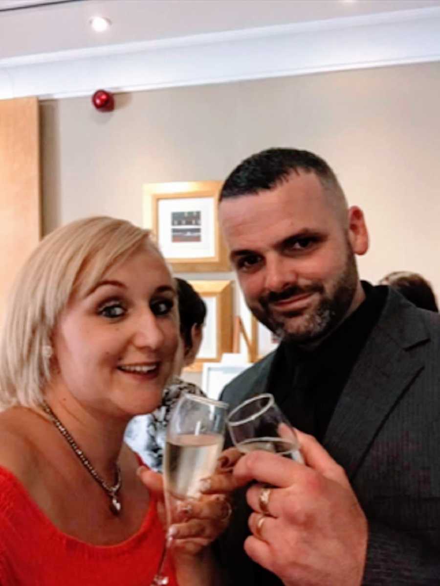 A husband and wife holding wine glasses