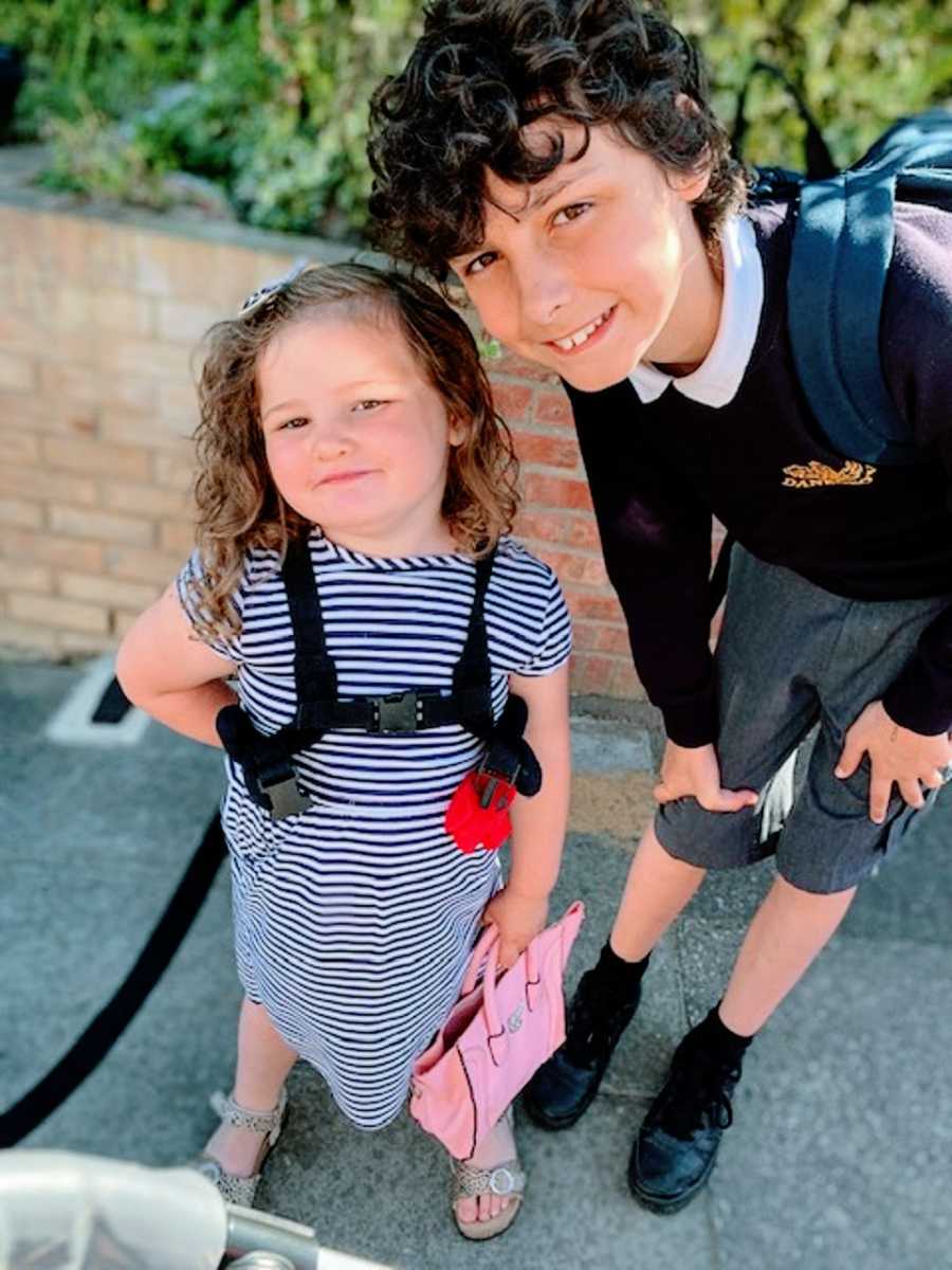 A little girl and her brother wearing backpacks