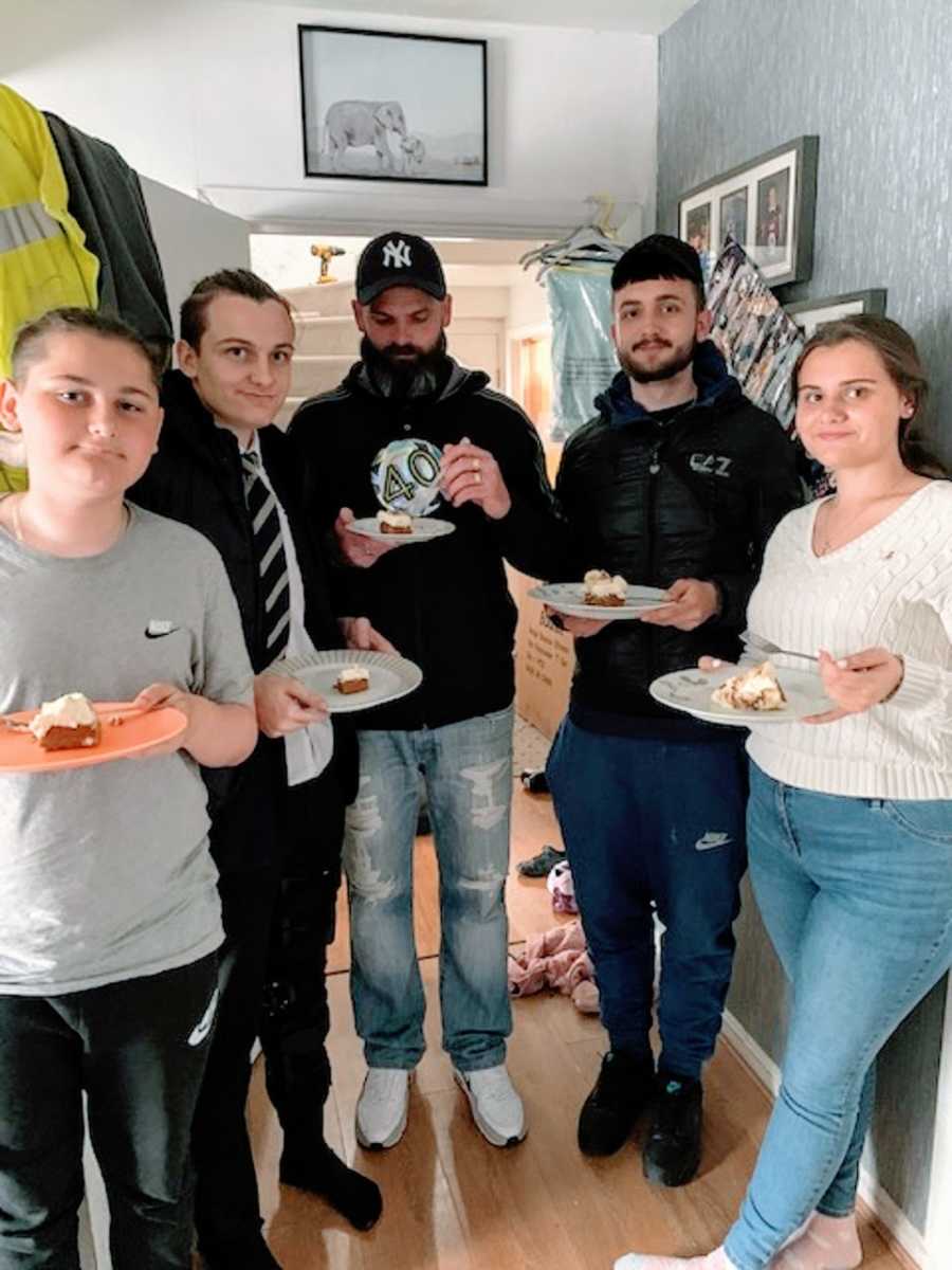 Four children and their father stand holding plates