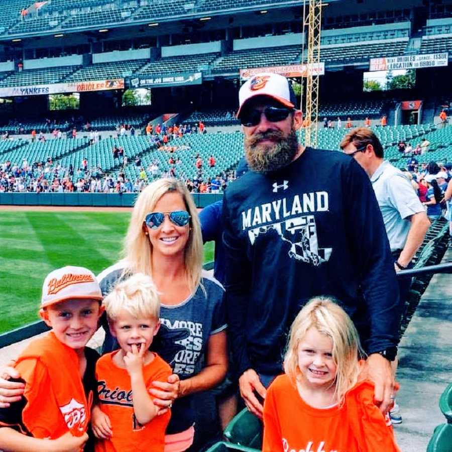 A woman stands with her husband and three children