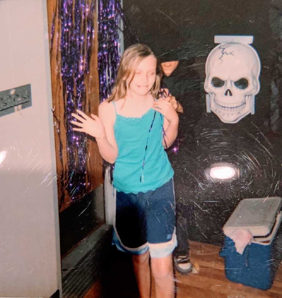 A young woman wearing a blue tank top and shorts