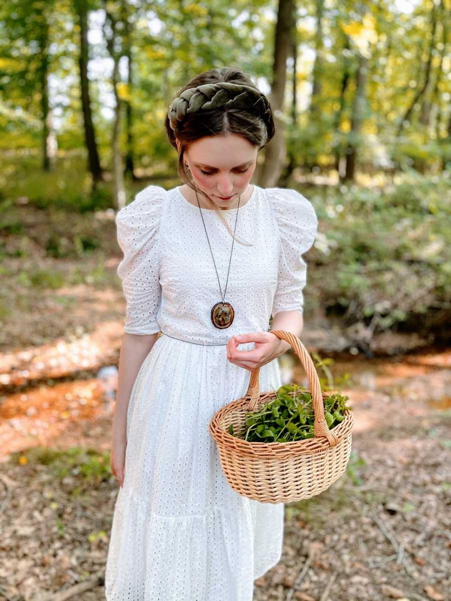 A young woman wearing a white dress and holding a basket