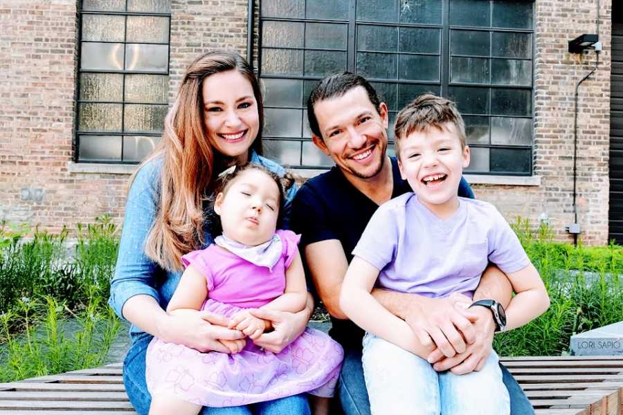 Parents sit with their two young children