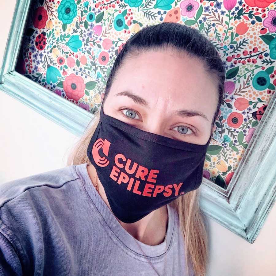 A woman wears a CURE Epilepsy mask