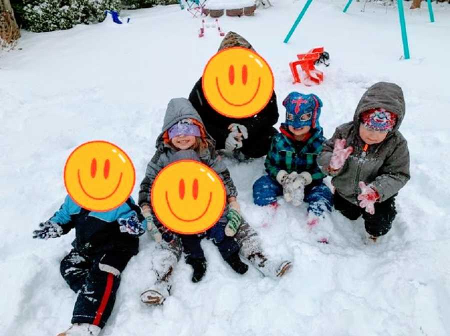 A group of children play with each other in the snow