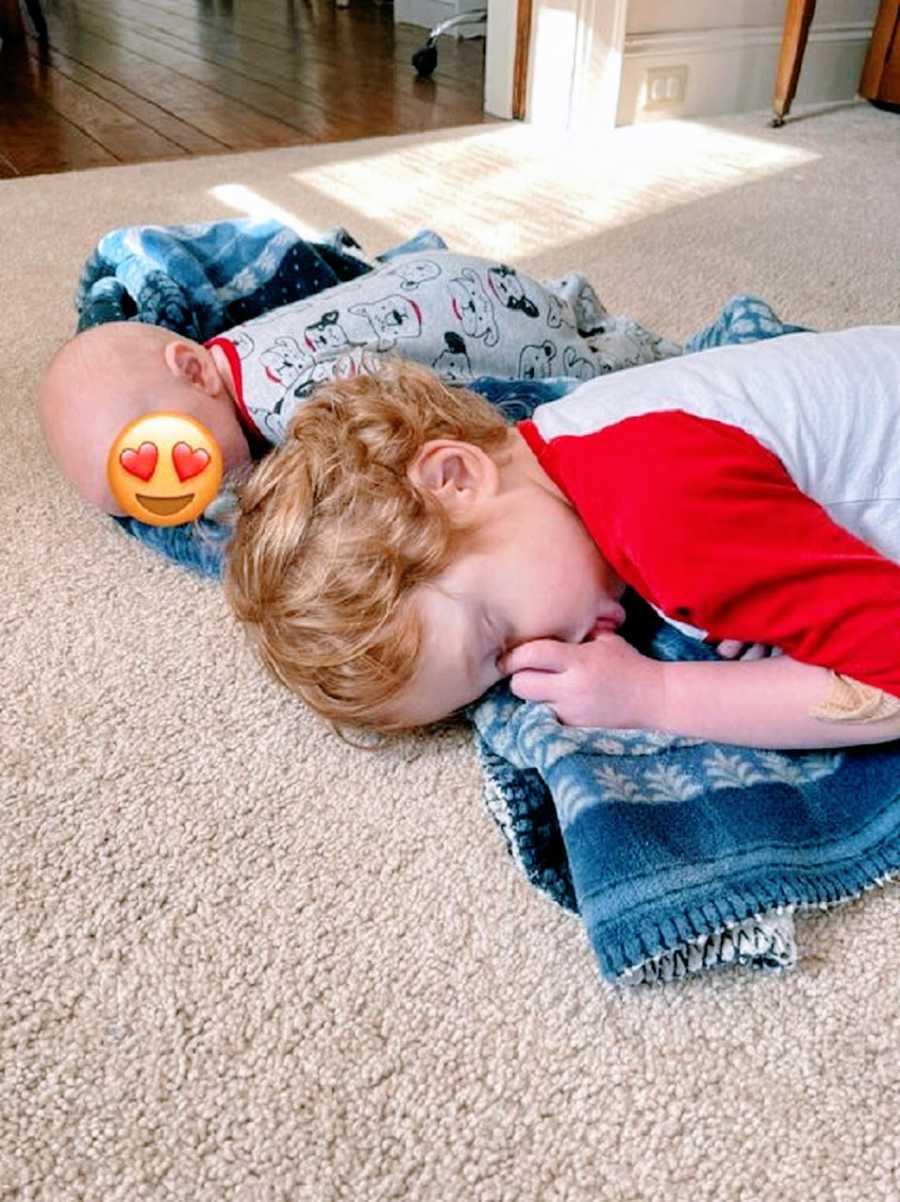 A toddler sleeps next to a foster baby