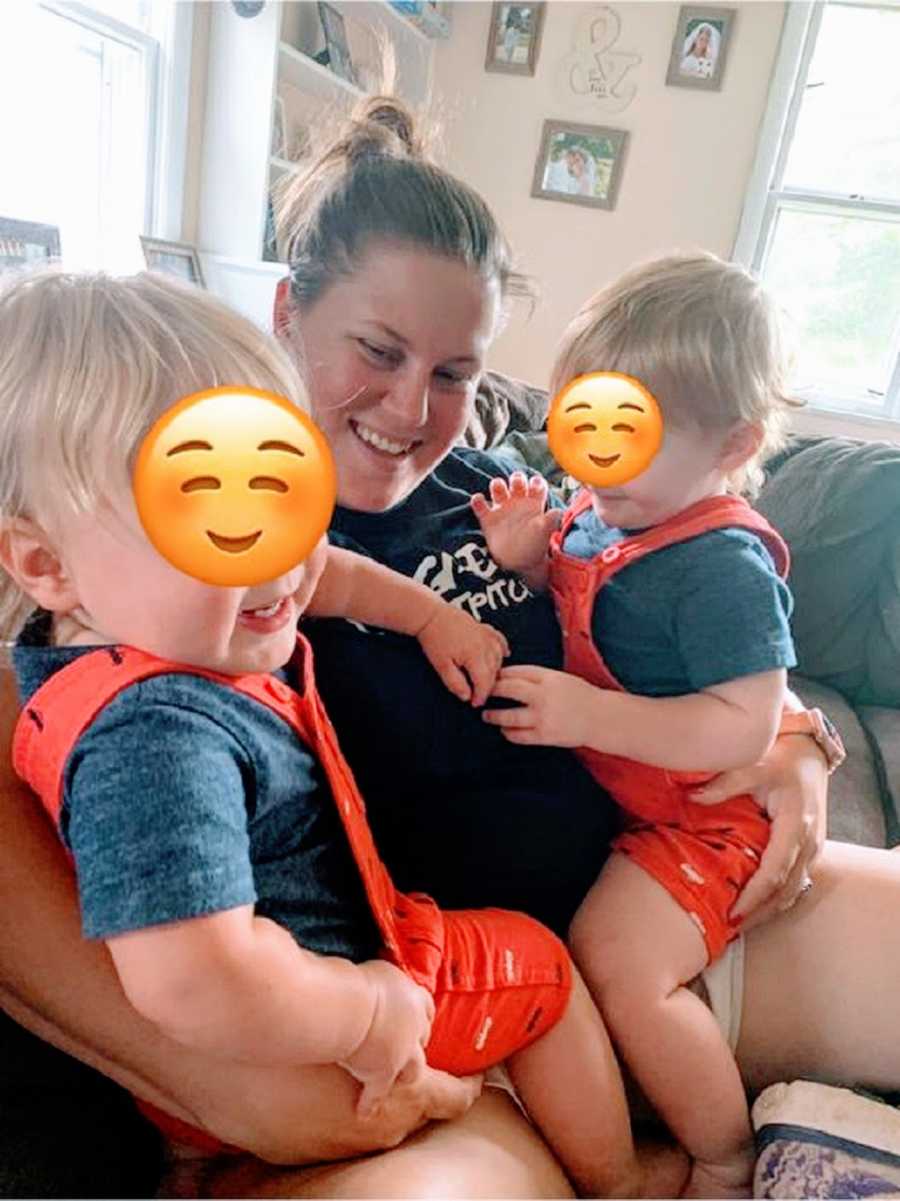 A mother sits with two foster children on her lap