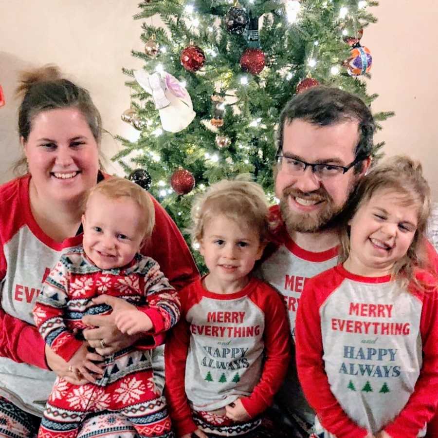 Parents with their 3 children dressed in matching holiday pajamas