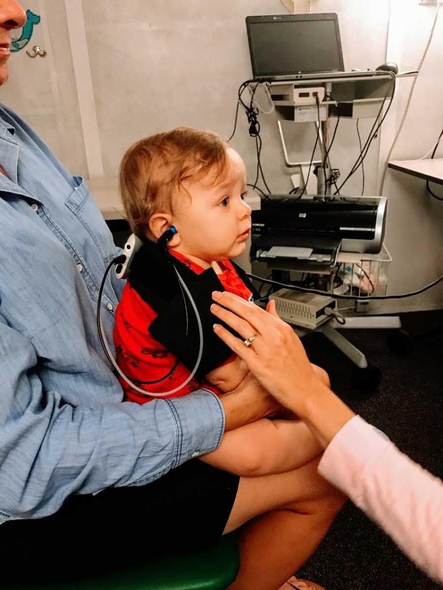 A little boy with wires hooked up to his head at a doctor's office