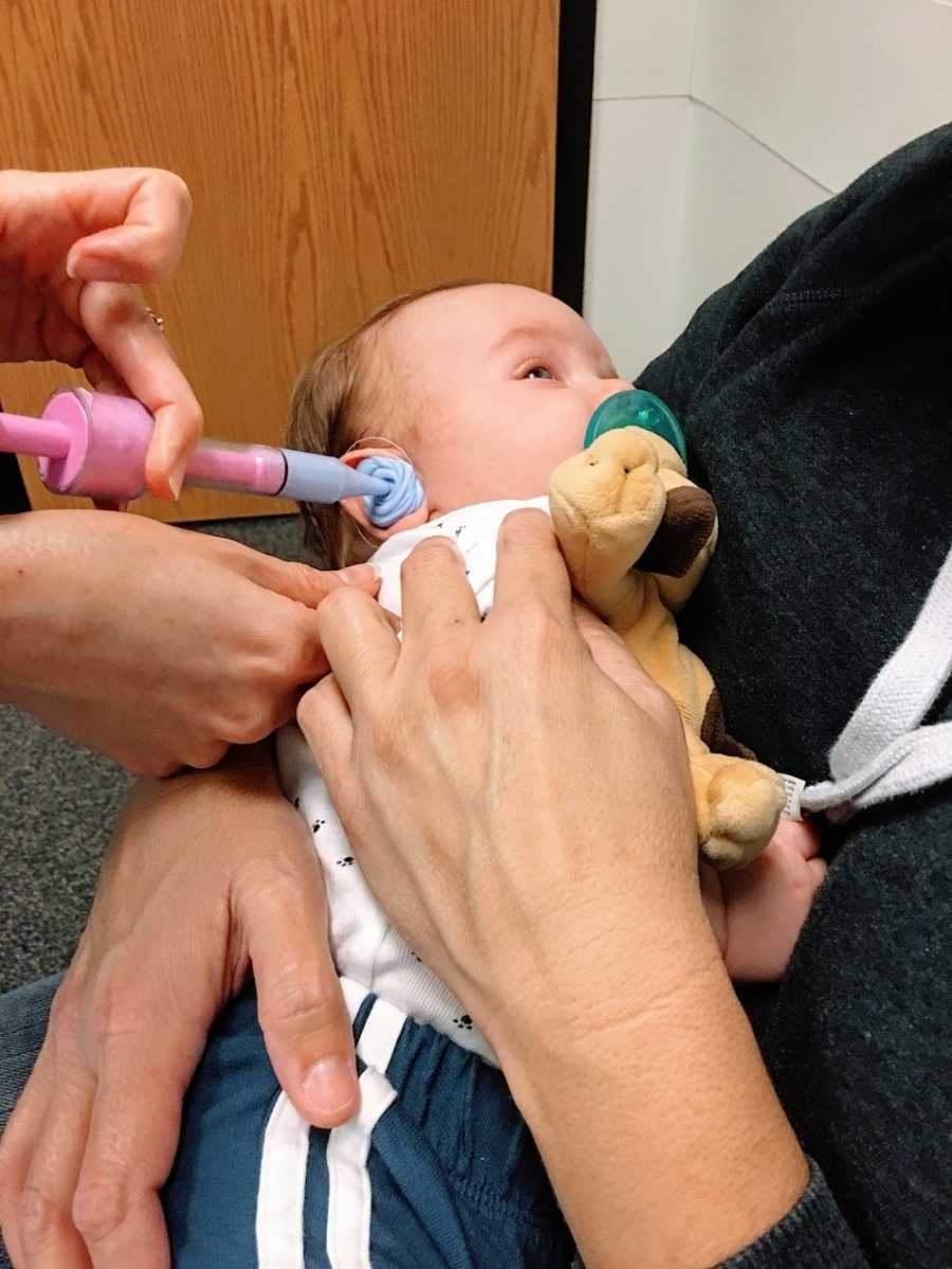 A little boy getting hearing aids at the doctor