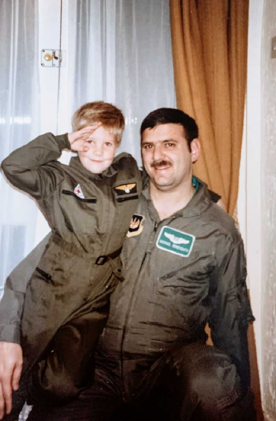 A man in a military uniform stands with a young boy