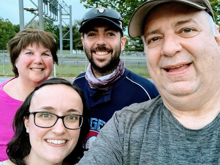 Parents stand with their son and daughter-in-law