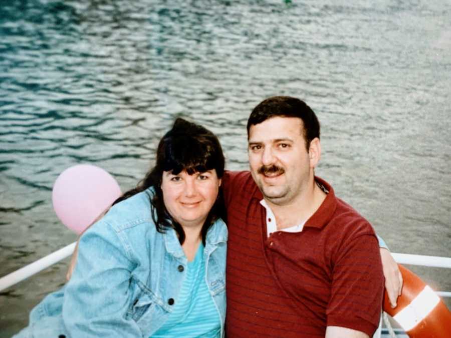 A man and his wife sit together in a small boat