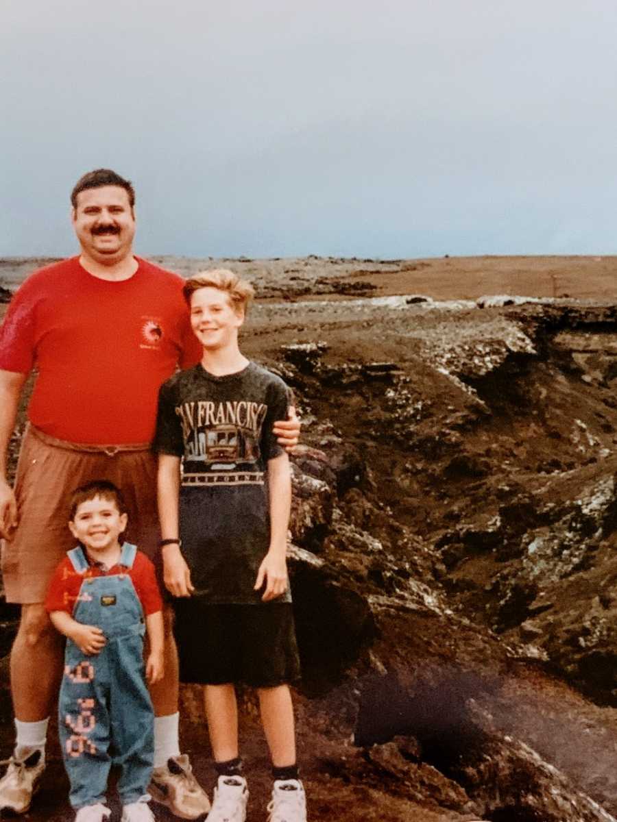 A man stands with his two young sons 