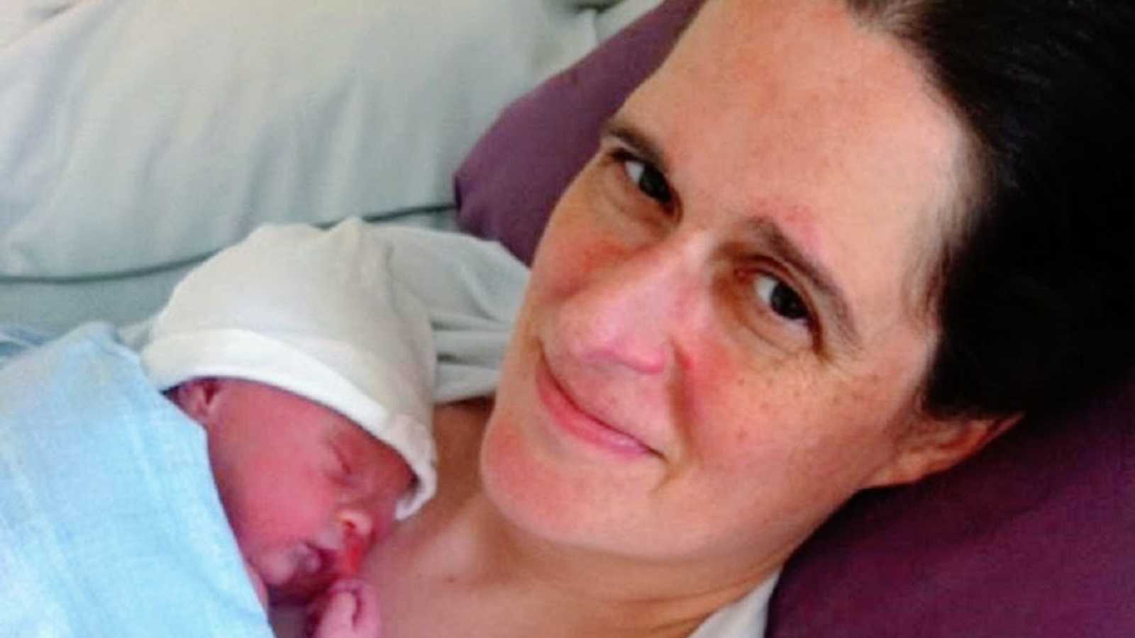 A mom lies in a hospital bed with her newborn