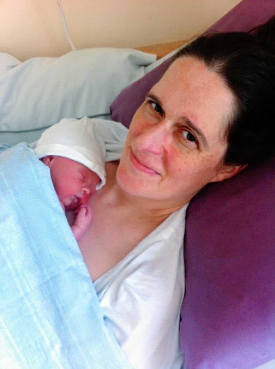 A woman visits her newborn who lies on her chest