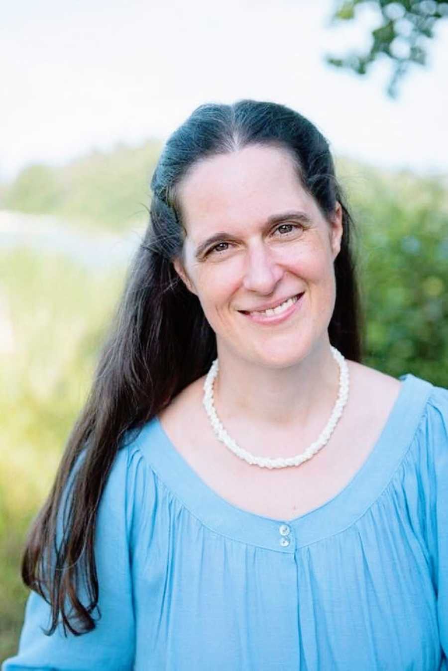 A woman with long hair wearing a blue shirt