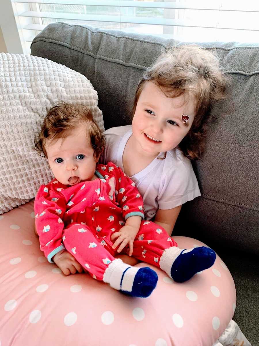 A little girl holds her baby sister