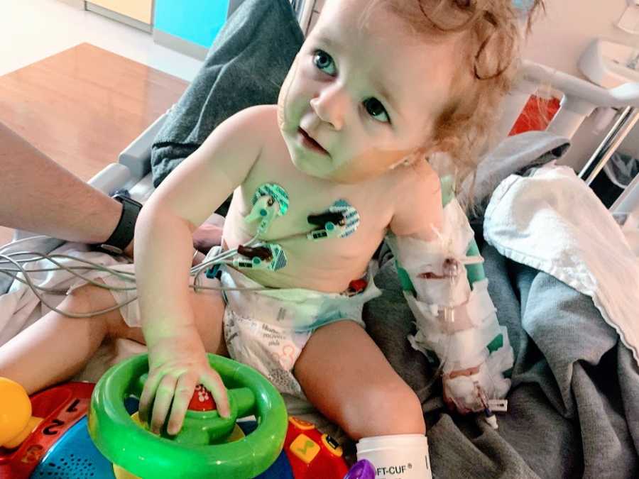 A little girl hooked up to wires in a hospital