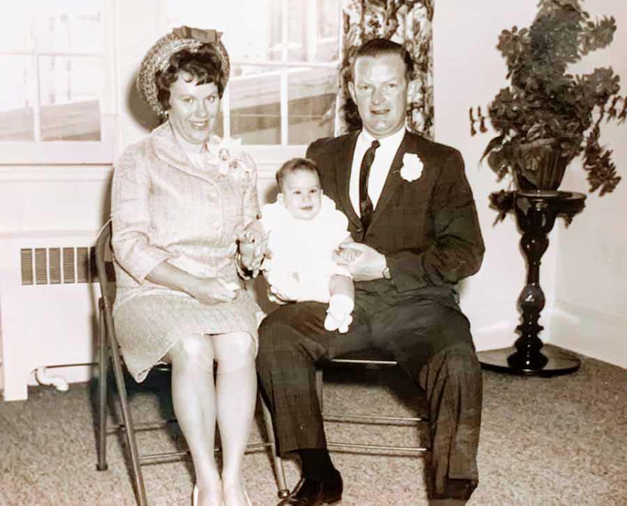 Parents sit with their child at her baptism