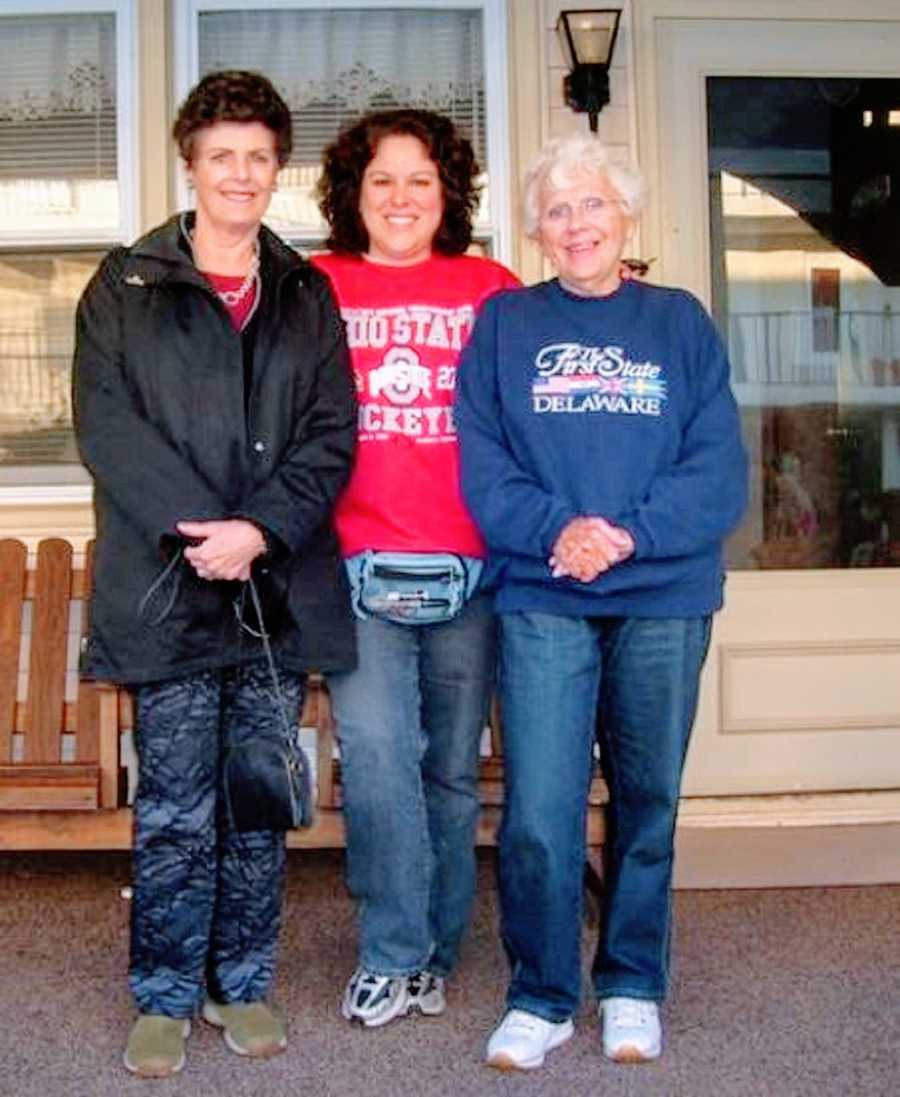 A woman stands with her adoptive and birth mothers