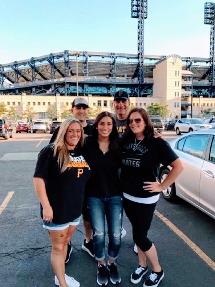 A family stand together outside a baseball stadium