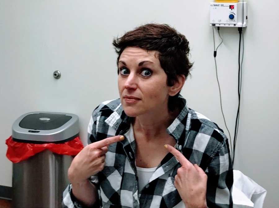 A woman points to her throat before a medical procedure