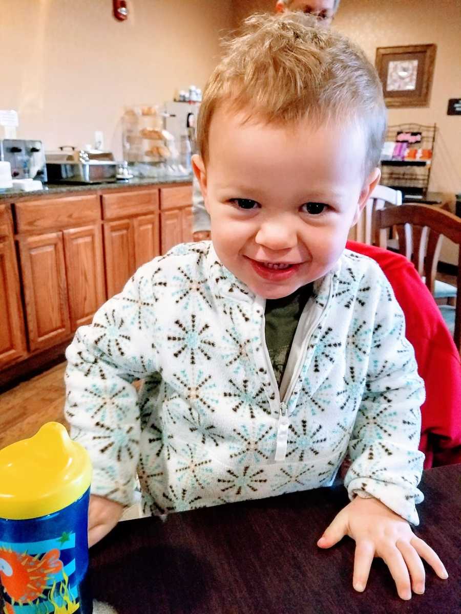 A little boy wearing a shirt with snowflakes on it