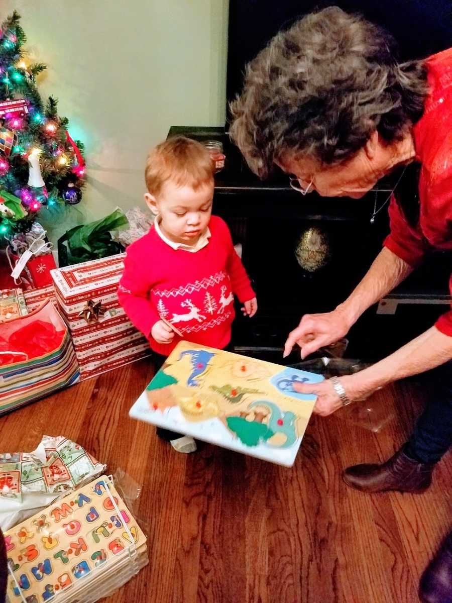 An older woman shows a toy to her adopted grandchild