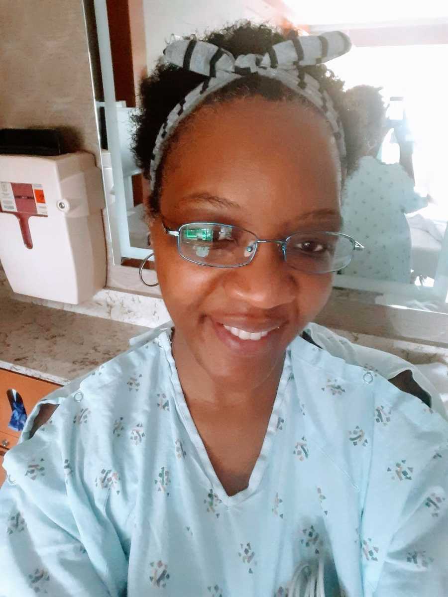 A woman smiling while wearing a hospital gown