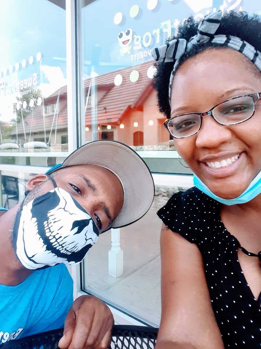 A woman and her husband wear masks at a restaurant