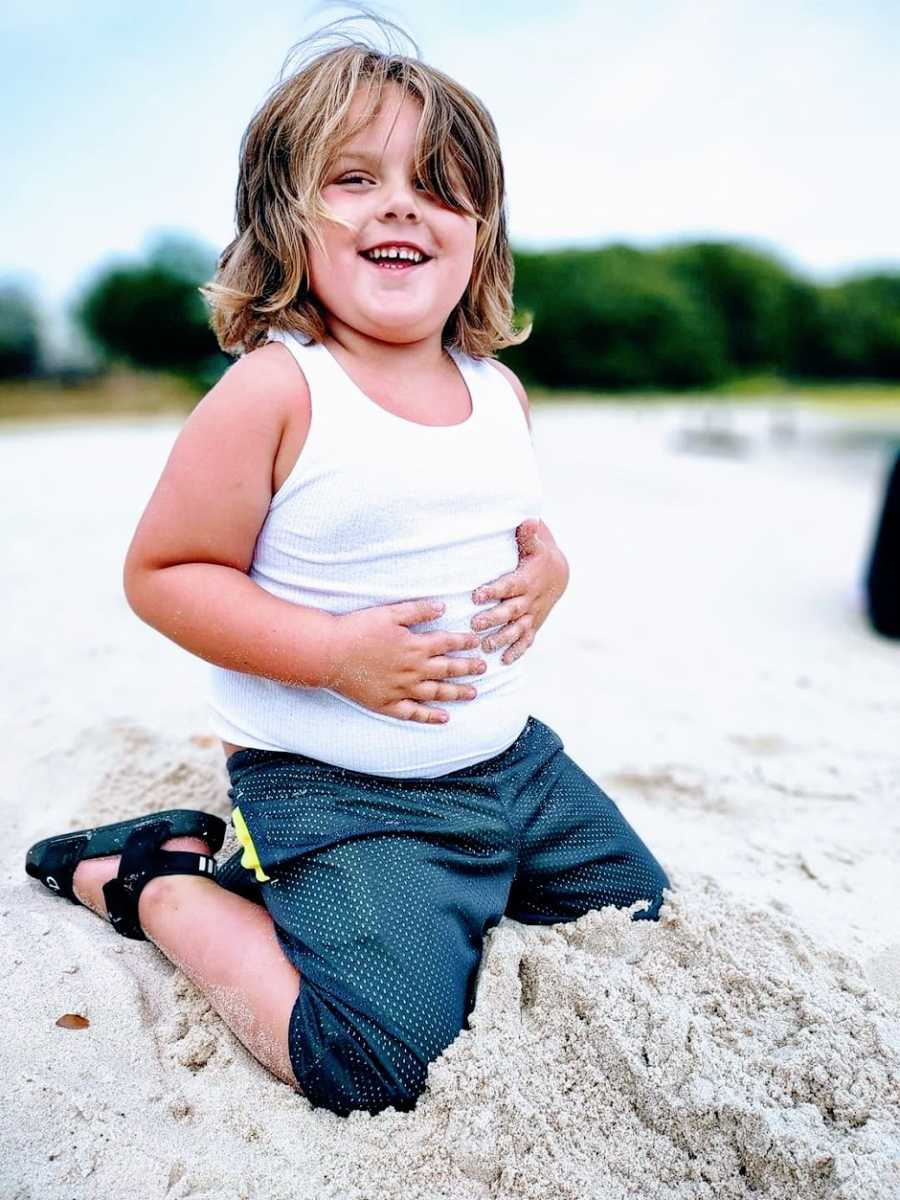 A little boy with autism plays in the sand